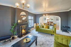 a living room with a green couch and a fireplace at Host & Stay - Regency Mansions Apartment in Redcar