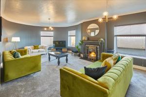 a living room with yellow furniture and a fireplace at Host & Stay - Regency Mansions Apartment in Redcar