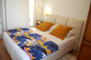 a bed with two yellow pillows on it in a room at Château Bégot in Lansac