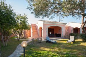 uma casa com um quintal com duas cadeiras e um pátio em Ville del Mar em San Teodoro