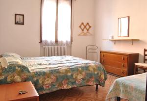 a bedroom with two beds and a dresser and window at Lombardi Ramazzini in Parma