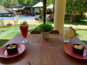 una mesa de madera con dos platos de comida y bebida en Solar Pipa 195, en Pipa