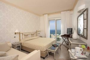 a bedroom with a bed and a living room at Hotel Posillipo in Gabicce Mare