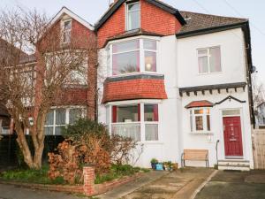 a white house with a red door at Sylvian in Bexhill