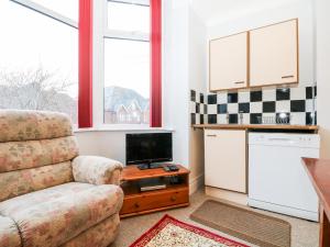 a living room with a chair and a tv at Sylvian in Bexhill