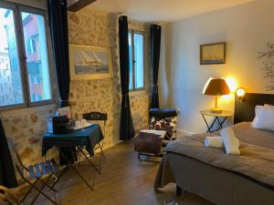 a bedroom with a bed and a table and chairs at Pitibi Maison d'Hote in Sanary-sur-Mer