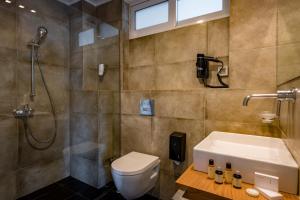 a bathroom with a shower and a toilet and a sink at Leto Nuevo Hotel in Nafplio