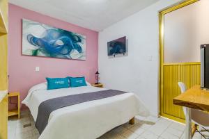 a bedroom with a bed and a painting on the wall at Ayenda Los Colorines de Coyoacán in Mexico City