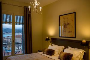 a bedroom with a bed and a window with a view at Leto Nuevo Hotel in Nafplio