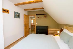 ein Schlafzimmer mit einem großen weißen Bett im Dachgeschoss in der Unterkunft Chalet Pr Dobravc in Bohinj