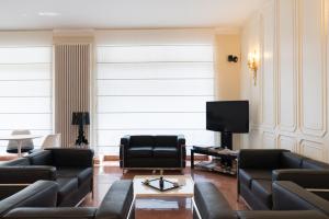 a living room with black leather furniture and a flat screen tv at Hotel Tourist in Turin +30 photos