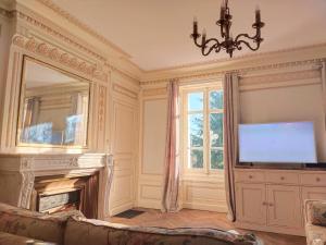 a living room with a fireplace and a large mirror at Château Bégot in Lansac