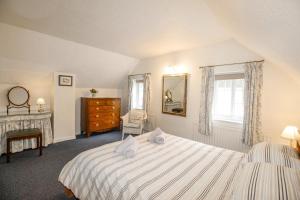 a bedroom with a bed and a dresser and a window at Cajun Cottage in Wareham