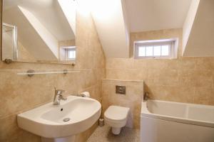ein Badezimmer mit Waschbecken, Toilette und Spiegel in der Unterkunft Cajun Cottage in Wareham + 36 Fotos