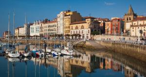 eine Gruppe von Booten, die in einem Hafen mit Gebäuden angedockt sind in der Unterkunft ANARAL-Casco Viejo Gijon-AUTOCHECK 24h in Gijón