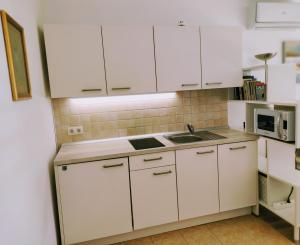 a kitchen with white cabinets and a sink at Apartma MAX in Moravske-Toplice