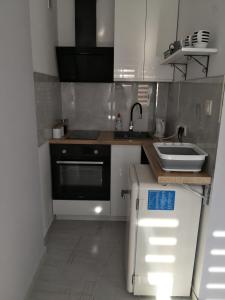 uma pequena cozinha com um lavatório e um frigorífico em Różowe sny em Klodzko