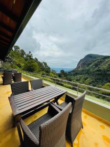a table and chairs on a balcony with a view at Zion View Ella Green Retreat in Ella