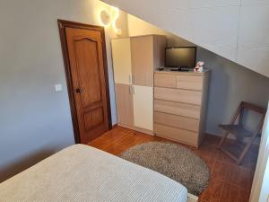 a small bedroom with a bed and a television at La Centinela, Geoparque Costa Quebrada in Miengo