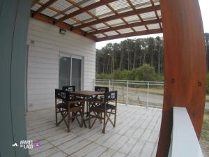 a patio with a table and chairs on a deck at Aparts del lago de los cisnes in Necochea