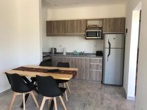 cocina con mesa de madera y nevera en Aparts del lago de los cisnes en Necochea