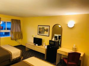 a hotel room with a bed and a desk with a television at M Star Hotel Mansfield in Mansfield