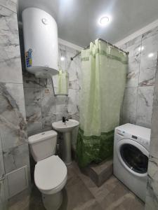 bagno con lavandino e servizi igienici e lavatrice. di Квартира a Gagra