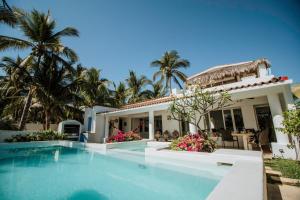 a villa with a swimming pool in front of a house at Villa Rincon del Mar & Villa Rincon de las Morenas in Coyuca