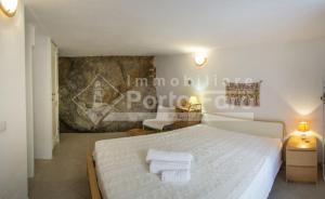 a bedroom with a white bed with towels on it at 13 PN - Vecchio Marino villino con tre camere in Palau