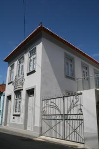 ein weißes Haus mit einem Tor davor in der Unterkunft Murtosa House in Torreira