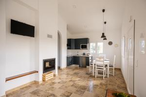 cocina y sala de estar con chimenea y mesa en QR Casas de Campo, en Vale de Santarém