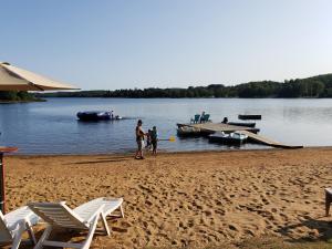 a couple of people standing on a beach with boats at Parkway Cottage Resort and Trading Post in Dwight