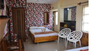 a bedroom with a bed and two chairs in it at Royal Sundarban Wild Resort in Jharkhali