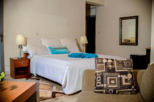 a bedroom with a bed and a couch and a mirror at One Click Hotel in Kigali