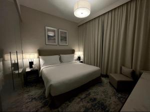 a hotel room with a bed and a chair at شقة فاخرة في فندق العنوان Two bedrooms apartment at address residences in Sharm