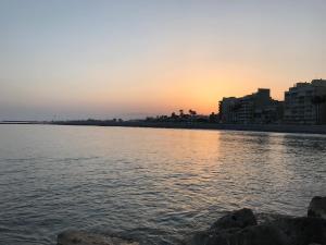 a sunset over a body of water with buildings at "Aqui se vive bien" in Burriana