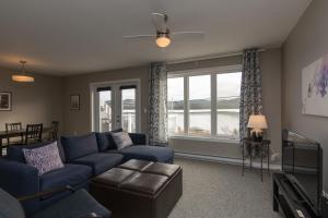 a living room with a blue couch and a large window at The Killick Inn & Suites in Arnold's Cove