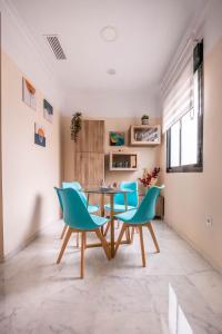 a dining room with blue chairs and a table at Slava Luxury Suite in Seville