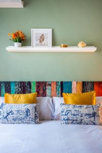 1 dormitorio con 1 cama con almohadas amarillas y azules en Slava Luxury Suite en Sevilla