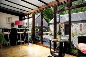 a living room with a bar with a view of a garden at Sheildaig Farm in Balloch