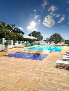 une grande piscine avec des chaises dans l'établissement Hotel Aldea Plaza, à Doradal