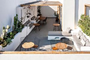 a patio with chairs and tables on a building at Lemon Suites Santorini in Fira