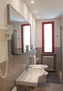 a bathroom with a sink and a toilet and a mirror at Aris Residence in Riccione