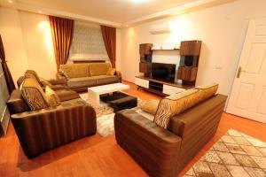 Una sala de estar con dos sofás y un televisor. en Berkay Villas 2, en Alanya