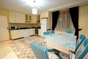 Una cocina y un comedor con mesa y sillas. en Berkay Villas 2, en Alanya