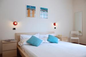 a bedroom with a white bed with blue pillows at Aris Residence in Riccione