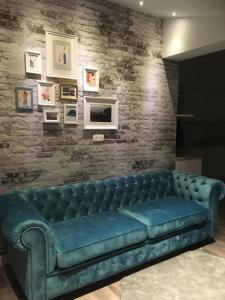 a blue couch in a room with a brick wall at Sunrise Fiesa in Piran