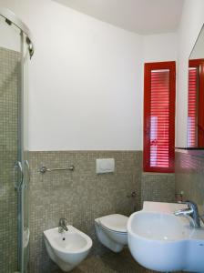 a bathroom with two sinks and a toilet and a shower at Aris Residence in Riccione