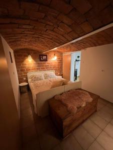 a bedroom with a bed and a brick wall at apartma "happy Scotts" in Starše