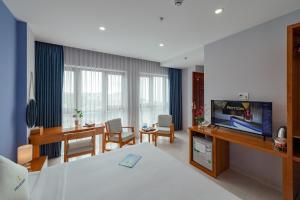 a hotel room with a bed and a television at Stellar Hotel in Phú Quốc